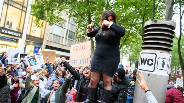 Kundgebungen gegen iranisches Regime in Hamburg und Berlin Eine Frau schneidet sich in Hamburg demonstrativ die Haare ab, um sich mit den Frauen im Iran zu solidarisieren.