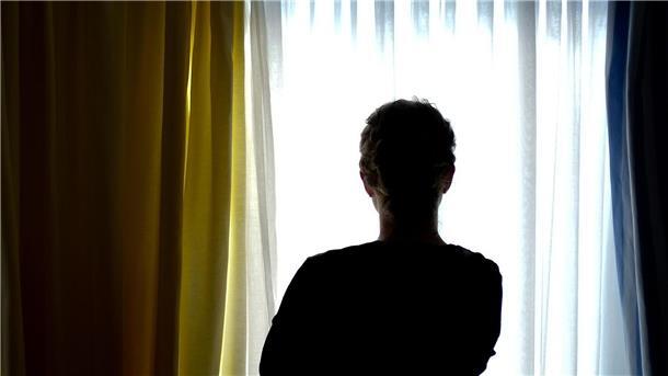 Eine Frau steht in einem Frauenhaus-Zimmer. 