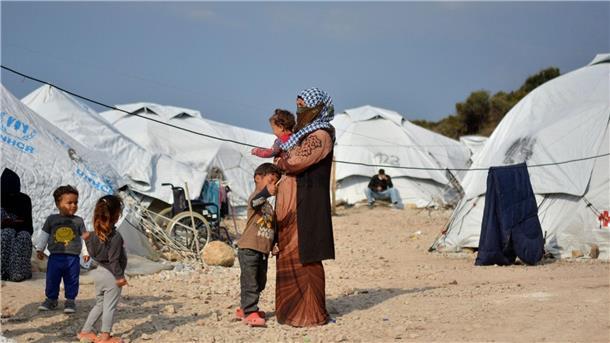 Berlin sieht Pläne für Asyl-Krisenverordnung kritisch Eine Frau steht mit ihren Kindern im Flüchtlingslager Kara Tepe in der Nähe von Mytilini auf Lesbos.