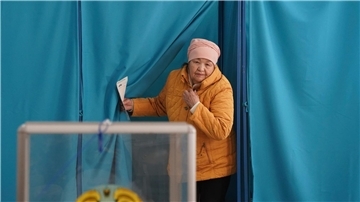 Eine Frau verlässt eine Wahlkabine in Almaty. Unter dem Eindruck der schweren Unruhen des vergangenen Jahres fanden in Kasachstan in Zentralasien vorgezogene Parlamentswahlen statt.