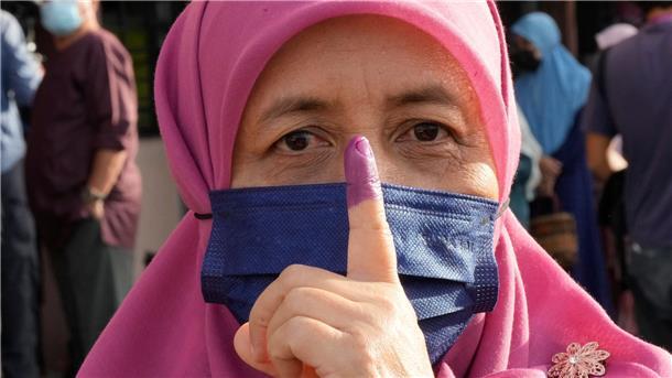 Enges Rennen bei Parlamentswahl in Malaysia Eine Frau zeigt ihren eingefärbten Finger nach der Stimmabgabe in Seberang Perai.