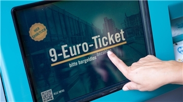 Eine Frau zieht sich an einem Fahrschein-Automaten in Frankfurt/Main ein 9-Euro-Ticket.