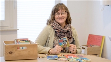Eine Frau hält das Pixi-Buch "Bummel, der Zug" in der Hand".