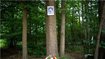 Eine Gedenktafel mit dem Abbild des NSU-Opfers Enver Simsek hängt 2018 am Tatort in Nürnberg an einem Baum.
