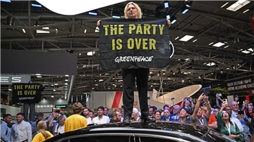 Eine Greenpeace-Aktivistin bei der Eröffnung der IAA auf dem Dach eines ausgestellten Autos.