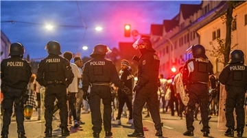 Eine Gruppe von Menschen wird nach Ausschreitungen bei einer Eritrea-Veranstaltung von Polizeikräften eingekesselt.