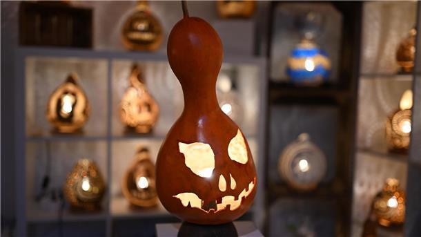 Eine handgefertigte Lampe aus einem Flaschenkürbis - mit Halloween-Fratze.