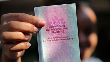 Eine junge Frau aus Afrika mit einem Ausweis für Flüchtlinge: „Aussetzung der Abschiebung (Duldung)“. Darunter ist der Vermerk: „Kein Aufenthaltstitel!“