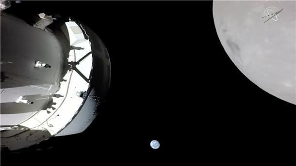 Nasa-Mission „Artemis 1“ erstmals nah am Mond vorbeigeflogen Eine Kamera an Bord der „Orion“-Kapsel zeigt das Raumschiff (l) im Weltraum, den Mond (r) und klein im Hintergrund die Erde.