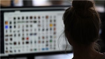 Eine Kriminaloberkommissarin sitzt in einem Büro vor einem Auswertungscomputer auf der Suche nach Kinderpornografie und Fällen von sexuellem Missbrauch.