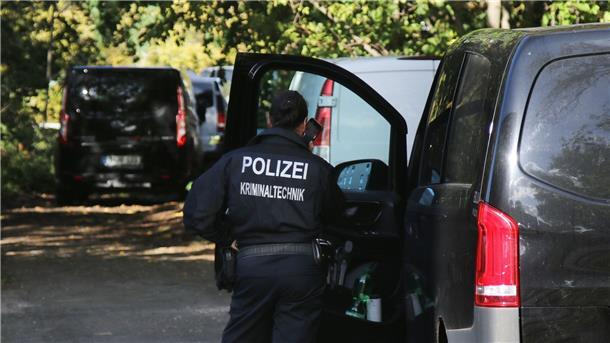 Eine Kriminaltechnikerin steht in der Nähe vom S-Bahnhof Hohenschönhausen neben Fahrzeugen der Polizei. Die Bahn wurde Opfer eines gezielten Angriffs.