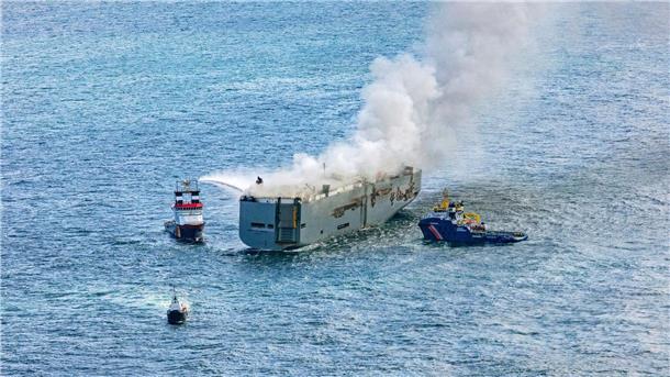 Reederei: Brennender Frachter hat 3783 Autos geladen Eine Luftaufnahme zeigt einen deutschen Notschlepper(l), der das Feuer auf einem Frachter bekämpft.