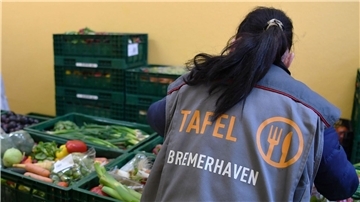 Mitarbeiterin der Tafel in Bremerhaven sortiert Gemüsekisten.