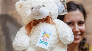 Eine Mitarbeiterin des Plüschtierherstellers Heunec präsentiert einen Stoffteddy, der mit dem Siegel der Fair Toys Organisation gekennzeichnet ist.