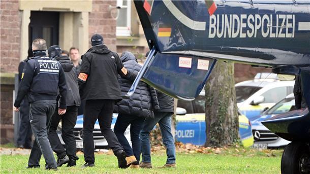 Razzia in „Reichsbürger“-Szene: Suche nach weiteren Spuren Eine Person (2.v.r.) wird von Polizisten aus einem Hubschrauber gebracht.