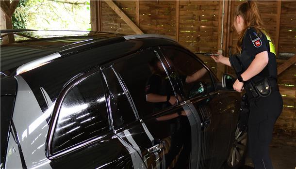 Eine Polizeibeamtin bei der Taortaufnahme in dem Carport in Moorausmoor. Der Besitzer des silbernfarbenen Autos, das mit teerhaltiger Flüssigkeit übergossen wurde, glaubt, dass er Ziel von Attacken ist, weil Blitzer Bernd an seinem Grundstück zur Geschwindigkeitsmessung auf der Landesstraße 116 aufgestellt wird.