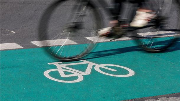 Eine Radfahrerin fährt in Leipzig über einen grün eingefärbten Radweg.