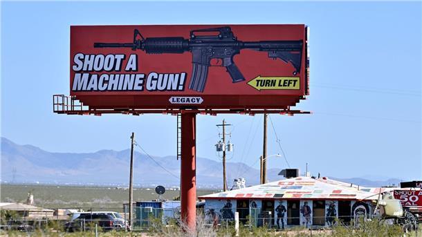 Bundesministerium sagt Teilnahme an US-Waffenmesse ab Eine Reklametafel im US-Bundesstaat Arizona wirbt für das Schießen mit einem Maschinengewehr auf einem Schießstand.