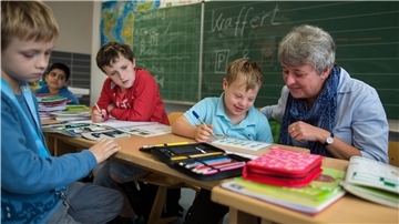 Eine Schulassistentin kümmert sich um einen Jungen mit Down-Syndrom. In Bremerhaven sollen die Schulassistenten künftig schlechter bezahlt werden.