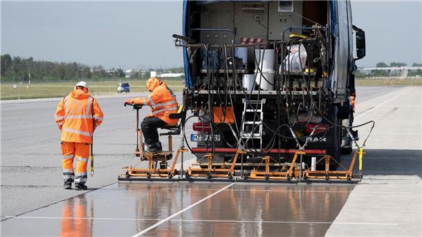 Eine spezielle Flüssig-Grundierung bringen Arbeiter mit einem Spezialfahrzeug auf der Landebahn Nordwest auf dem Flughafen in Frankfurt an. Am Frankfurter Flughafen hat der Betreiber Fraport die frisch sanierte Landebahn Nordwest nach wenigen Betriebsstunden wieder gesperrt.