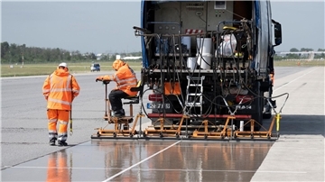 Eine spezielle Flüssig-Grundierung bringen Arbeiter mit einem Spezialfahrzeug auf der Landebahn Nordwest auf dem Flughafen in Frankfurt an. Am Frankfurter Flughafen hat der Betreiber Fraport die frisch sanierte Landebahn Nordwest nach wenigen Betriebsstunden wieder gesperrt.
