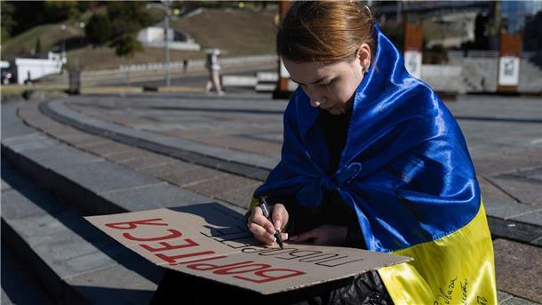 Eine Studentin in Kiew schreibt die ersten Worte des ukrainischen Gedichts „Kämpfe weiter - du wirst siegen“ von Taras Schewtschenko auf ein Plakat.