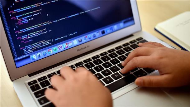 Eine Teilnehmerin arbeitet in Berlin bei einem Programmierkurs an einem Laptop.