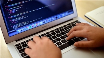 Eine Teilnehmerin arbeitet in Berlin bei einem Programmierkurs an einem Laptop.