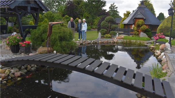 Drei Menschen an einem Teich