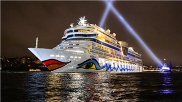 Ein Schiff fährt beleuchtet in der Dunkelheit