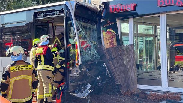 Linienbus kracht in Dönerladen Einsatzkräfte der Feuerwehr untersuchen den Linienbus, der zuvor in einen Dönerladen gekracht war.