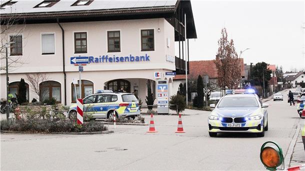 Autopanne vorgetäuscht: Geldtransporter überfallen  Einsatzkräfte der Polizei nach dem Überfall auf einen Geldtransporter in der Nähe einer Bank in Großkarolinenfeld in Bayern.