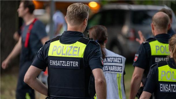 Einsatzkräfte der Polizei stehen in der Nähe des Unfallortes.