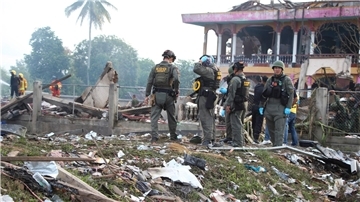 Einsatzkräfte des Kampfmittelräumdienstes untersuchen die Überreste eines durch eine Explosion zerstörten Gebäudes in Thailand.