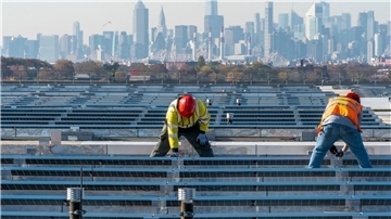 Elektriker installieren im New Yorker Stadtteil Queens Solarpaneele. Die US-Regierung hebt Zoll-Ausnahmen für bestimmte Solar-Importe auf.