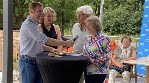 Vier Menschen stehen an einem Pult und unterhalten sich.