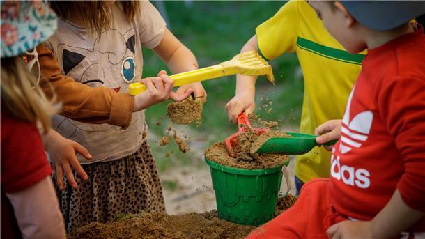 Keine höheren Kita-Gebühren: Gyhum hat ein Herz für Eltern Kinder spielen mit Sandspielzeug in einem Sandkasten