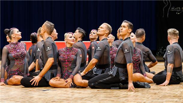 Tänzerinnen und Tänzer des A-Teams der TSG Bremerhaven sitzen auf dem Fußboden.