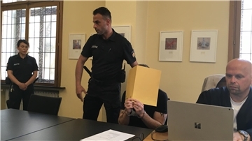 Angeklagter hinter Aktendeckeln