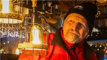 Ein Mann im Lichterschein einer Glühweinbude