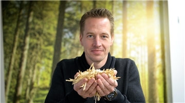 Ein Mann hält Holz in der Hand.