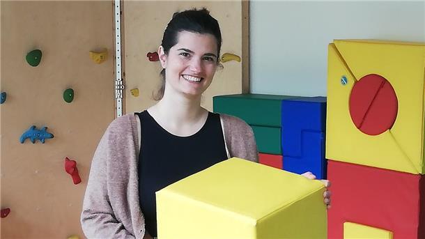 Frau mit gelbem Hocker in den Händen 