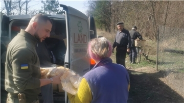 Erik N. übergibt in der Nähe von Borodjanka einer Frau Lebensmittel. Der Cuxhavener hat sich in der Ukraine als Freiwilliger der Fremdenlegion angeschlossen, er kämpft nach eigenen Angaben aber nicht.