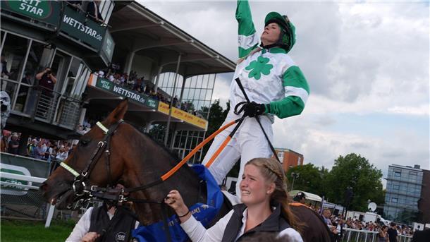 Erste Frau gewinnt deutsches Galopp-Derby Erinnerung an ihren Vater: Nina Baltromei zeigt nach ihrem historischen Sieg beim deutschen Galopp-Derby mit dem Zeigefinger gen Himmel.