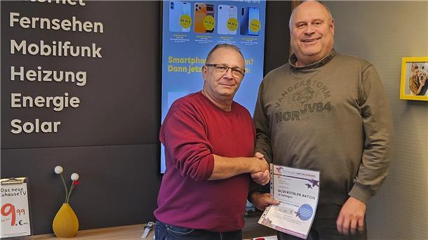 Erster Goldtaler des Jahres: SatCom-Geschäftsführer Harald Stiebitz (rechts) übergibt einen 50-Euro-Einkaufsgutschein als Sofortgewinn an seinen Kunden Ulrich Andres.