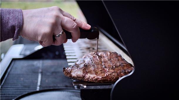 Es geht mit indirekter Hitze und einem Grillthermometer weiter: Christian Schwarz legt das Fleisch auf den Warmhalterost. Dort zieht es auf eine Kerntemperatur von 54 Grad hoch – er mag sein Fleisch medium rare. Medium ist ein Flanksteak, wenn die Kerntemperatur bei etwa 56 bis 60 Grad liegt. Während das Fleisch auf die gewünschte Temperatur hochzieht, legt er das Brot auf den Rost und grillt es von beiden Seiten, bis es kross ist.