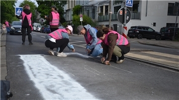 Fabian Beese (Zweiter von rechts) sprüht mit weiteren Aktivisten mit weißer Farbe einen illegalen Zebrastreifen auf den Bremer Osterdeich.