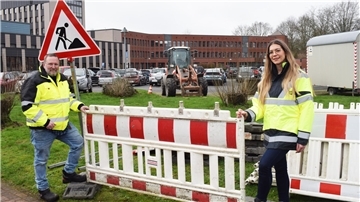 Fachdienstleiterin Denise Schönenberger und Projektleiter Thilo Früchtnicht weisen auf die Sperrung des Beschäftigtenparkplatzes beim Kreishaus in Brake hin.