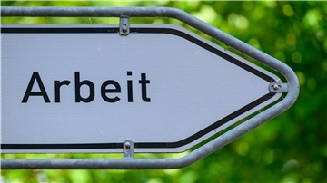 Blick auf einen Wegweiser mit der Aufschrift „Arbeit“. 