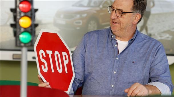 Fahrschüler müssen oft lange auf Prüfung warten Fahrlehrer Horst Wintgen sitzt mit Ampel und Verkehrsschild im Übungsraum seiner Fahrschule.